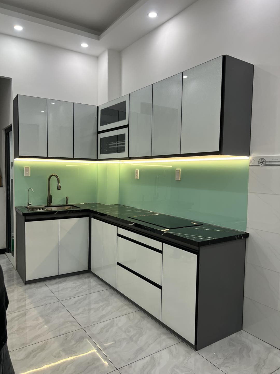 Tủ bếp chữ L hiện đại cánh kính